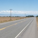 Highway 14/16/20 in Emblem divides two fields; one planted, and the other left fallow due to low water availability Tuesday, July 7. Avery Howe