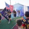 Senior Jesse Brown carries the Buff flag alongside junior Phillip Thomas carrying the American flag as the varsity football team enters the stadium at the start of their homecoming game Friday night. Standing on each side were members of the Greybull Rec District intramural football team and the Greybull Middle School football team. Lisa Kunkel