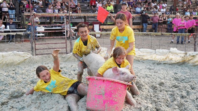 The team Hog Hooligans attempt to get their pig into the barrel during the pig wrestling competition Thursday evening at the Big Horn County Fair in Basin. From left, Ellie Thiel, Dalton Bankert, Harmony Hopkin, and Trinity Link. Lisa Kunkel